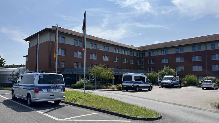Außenansicht JVA Bielefeld-Senne mit Polizeiautos