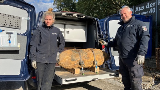 Einsatzkräfte mit der entschärften Bombe