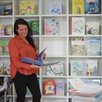 Eine Frau vor einem Regal mit Kinderbüchern