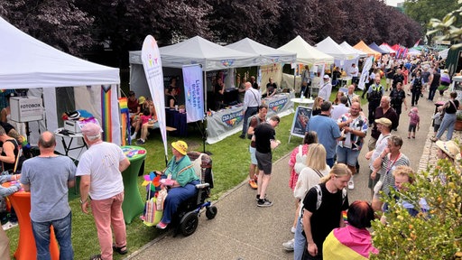Viele Menschen besuchen die Stände beim CSD in Solingen.