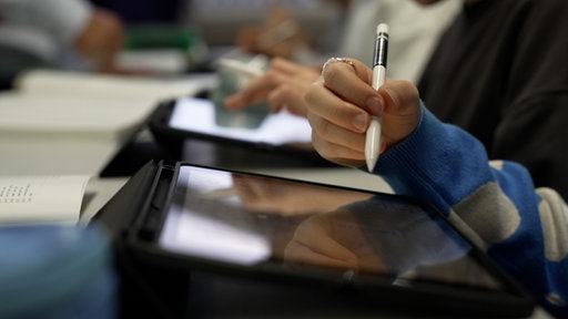 Schülerinnen und Schüler arbeiten mit iPads im Unterricht. 