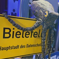 Ein Daten-Krake auf dem Ortsschild von Bielefeld