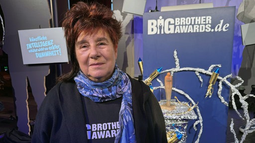 Eine Frau steht vor dem Big Brother Award