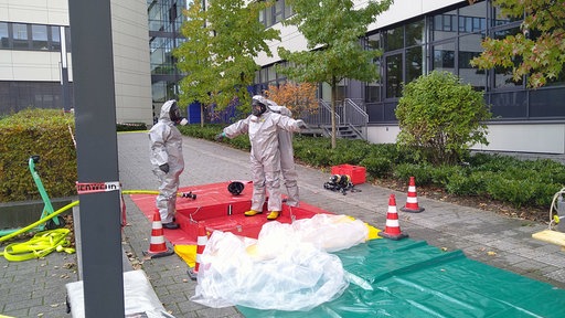 Feuerwehrleute in Schutzanzügen im Dekon