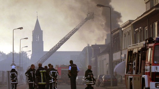 Feuerwehrleute löschen brennende Häuser in Enschede.