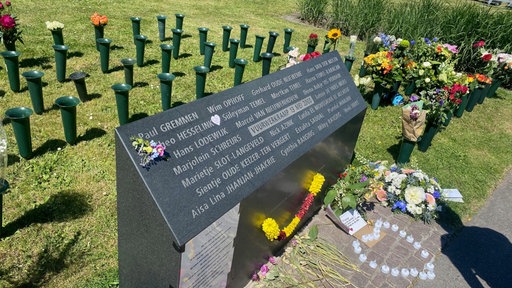 Die Gedenkstätte in Enschede, daneben liegen Blumen. 