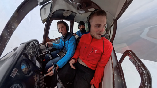 Drei Männer sitzen in einem Klein-Flugzeug