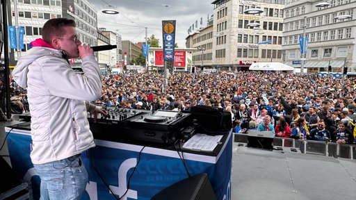 Der DJ aus dem Club Cafe Europa ruft ins Mikrofon und macht Stimmung.