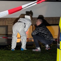 Zwei Polizeibeamte stehen vor dem Fenster des Kellers, wo die Leiche gefunden wurde.