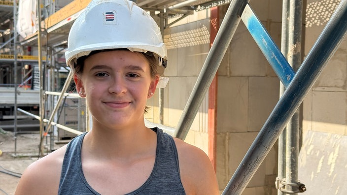 Greta Möller mit Helm vor der Baustelle