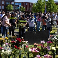 Viele Menschen legen Blumen an der Gedenkstätte nieder