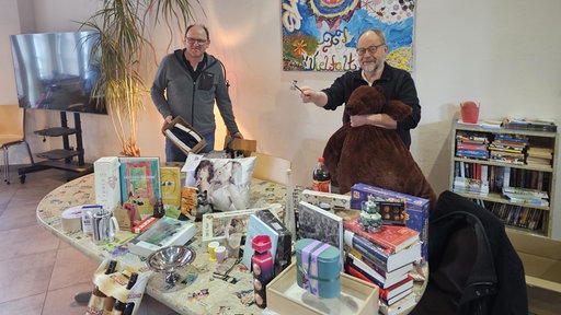 Verantwortliche der Weihnachts-Auktion präsentieren die Geschenke