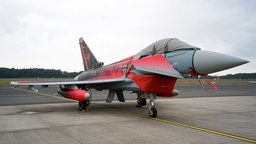 Ein roter Jet ist noch mit Planen abgedeckt
