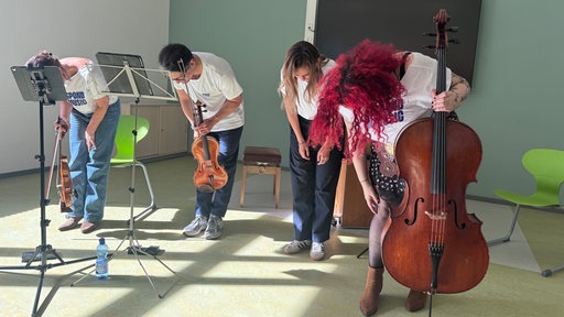 Die vier Musikerinnen und Musiker verbeugen sich vor dem Publikum