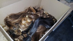 Eine Kiste voll mit Haarzöpfen, die gespendet werden.