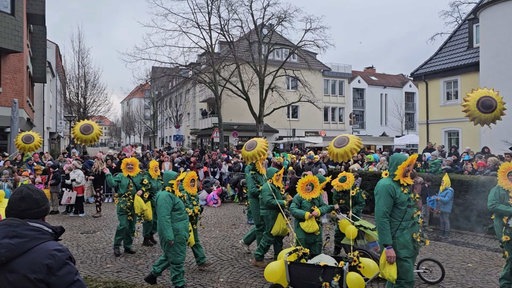 Manche Personen sind als Sonnenblumen verkleidet
