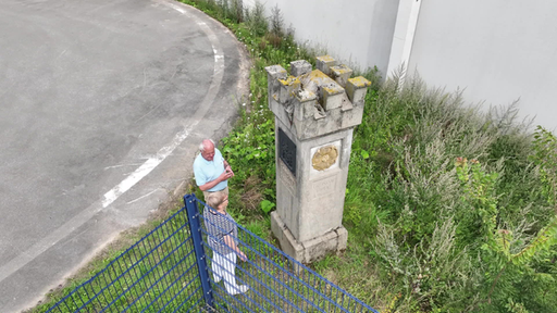 Menschen stehen vor dem Grenzstein