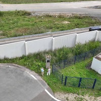 Der Grenzstein hinter der Lärmschutzmauer