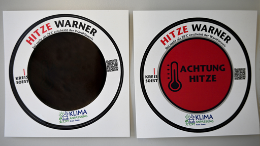Zwei runde Aufkleber einer mit der Aufschrift "Hitze Warner"
