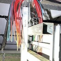 Beschädigte Kabel hängen an einer PV-Anlage herunter