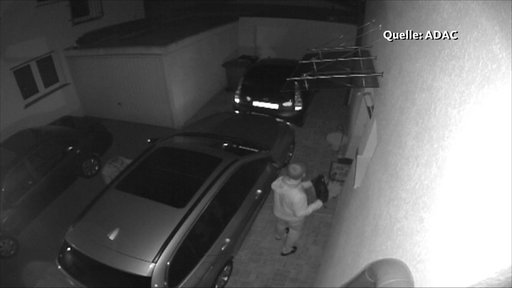 Einbrecher auf einer Überwachungskamera beim Autodiebstahl