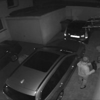 Einbrecher auf einer Überwachungskamera beim Autodiebstahl