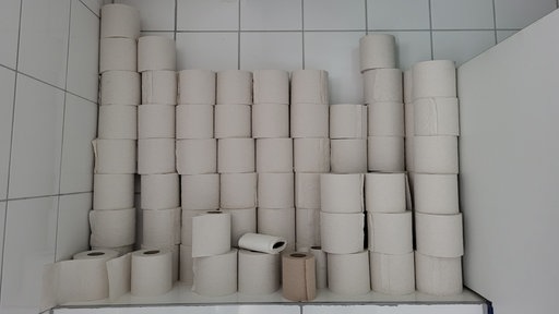 Ein hoher Stapel Klopapier türmt sich auf der Toilette.