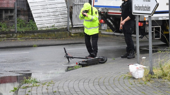 Ein Expertenteam der Polizei untersucht den E-Scooter Unfall, im Hintergrund steht der LKW