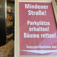 Ein Schild auf den Tresen vom Impiss mit dem Aufruf die parkplätze und Bäume zu erhalten