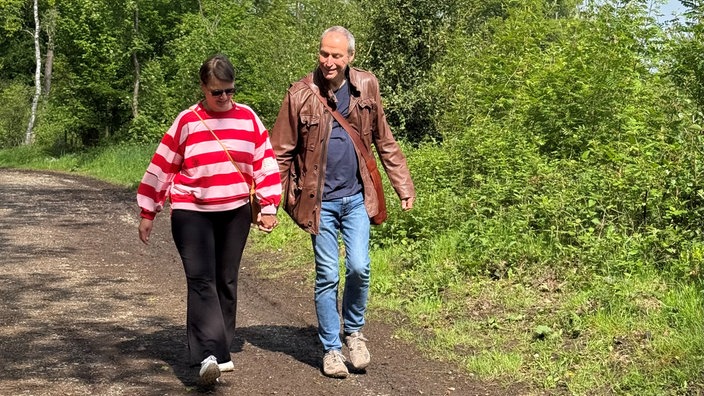 Mann und Frau gehen händchenhaltend spazieren