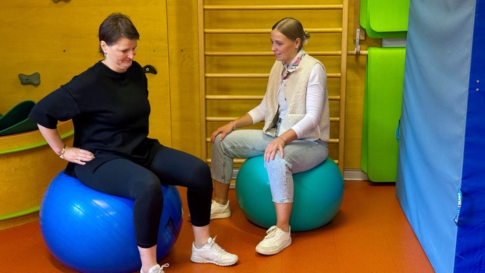 Zwei Frauen sitzen auf Gymnastikbällen