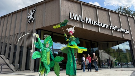 Theater Figuren posieren vor dem neuen Gebäude