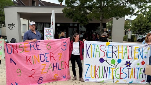 Eltern und Kinder protestieren mit bunten Plakaten