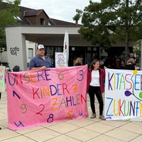 Eltern und Kinder protestieren mit bunten Plakaten