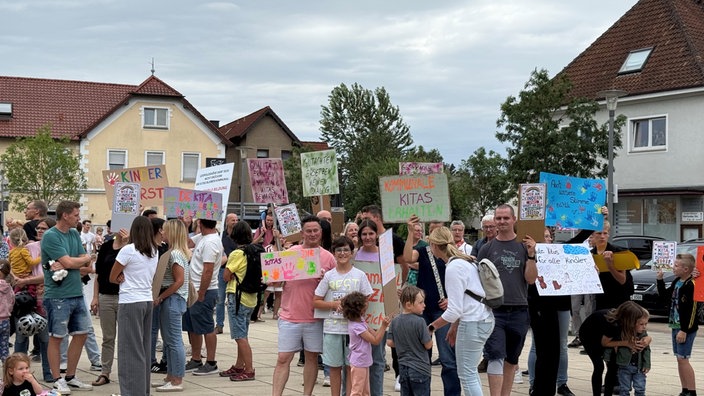 Eltern und Kinder protestieren mit bunten Plakaten