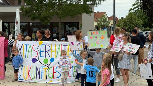 Eltern und Kinder protestieren mit bunten Plakaten