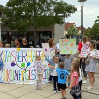 Eltern und Kinder protestieren mit bunten Plakaten