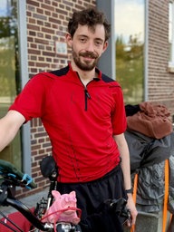 Konstantin Wodowos steht mit seinem Fahrrad vor einem Gebäude