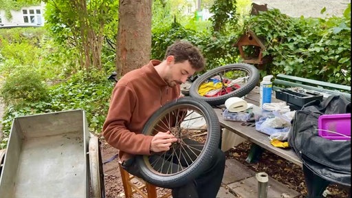 Konstantin Wodowos schaubt an einem Reifen.