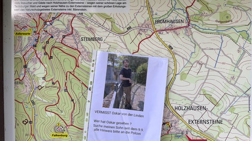 Ein Suchaufruf nach einem Vermissten vor einer Wanderkarte.