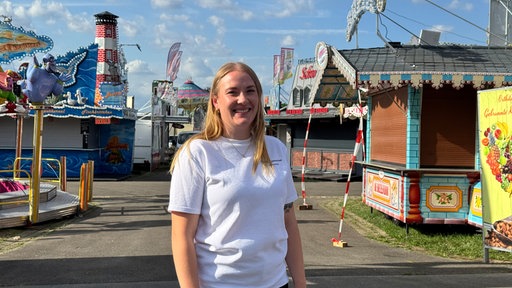 Marktmeisterin Juliane Helmich steht vor Fahrgeschäften des Blasheimer Markts