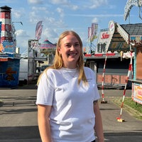 Marktmeisterin Juliane Helmich steht vor Fahrgeschäften des Blasheimer Markts
