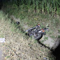 Ein Motorrad liegt nachts in einem Straßengraben neben einer Landstraße in Espelkamp im Kreis Minden-Lübbecke. Die Unfallstelle ist im Hintergrund abgesichert.