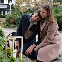 Ferris und Stella Fechner knien vor einer Kerze am Bahnhofsparkplatz in Bad Oeynhausen