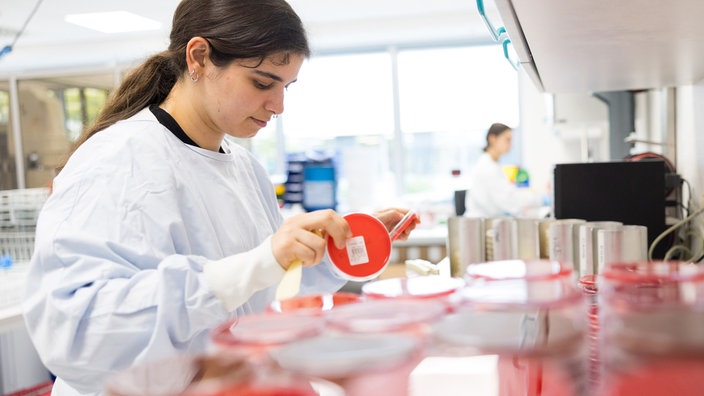 eine Mitarbeiterin im Zentrallabor der Mühlenkreiskliniken prüft Behälter