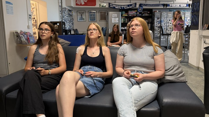 Drei Mädchen auf dem Sofa im Fan-Club.