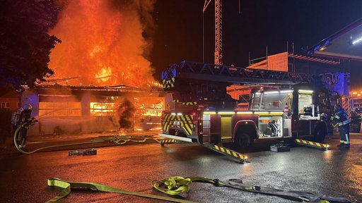 Ein Löschfahrzeug vor einem brennenden Gebäude