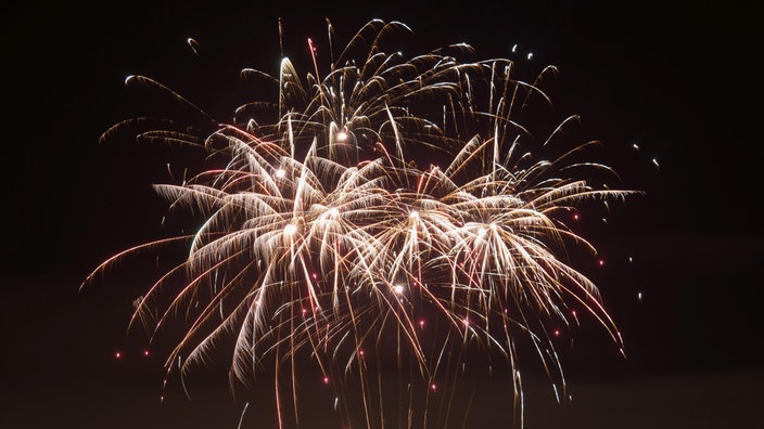 explodierende Feuerwerksraketen erleuchten den dunklen Himmel