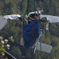 Ein Flugzeugwrack hängt an einem Seil