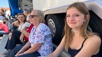 Junges, blondes Mädchen lächelt in die Kamera
